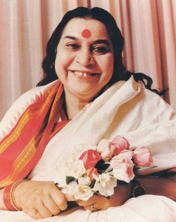 Shri Mataji Nirmala Devi sitting, smiling and holding a bouquet of roses